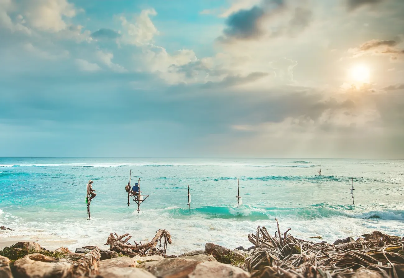 The lighthouse and shoreline path at Galle under a pink evening sky
